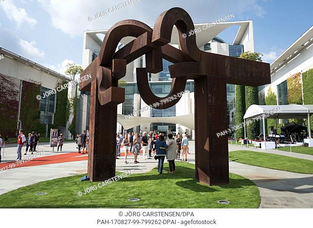 Visitors take a picture underneath a sculpture of Eduardo Chillida during the Open Day of the German federal government in the Federal Chancellery in Berlin