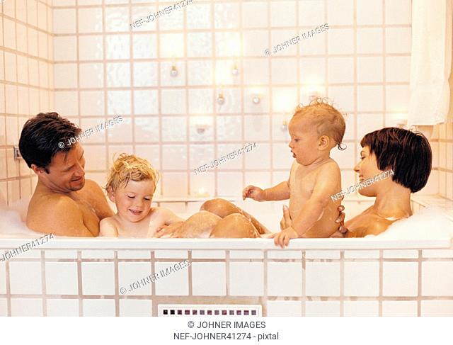 Man and woman with children bathing in the tub