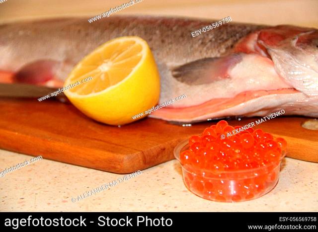 Rainbow trout fish red caviar and lemon. Cooking fish dish with lemon. Tasty fish dish. Cooking red caviar and fish meat. Red caviar with lemon