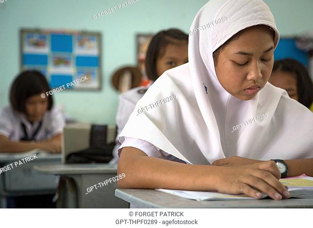 YOUNG PRIMARY SCHOOL GIRL WEARING A CHADOR (MUSLIM) IN A READING LESSON, SUAN LUNG SCHOOL, BANG SAPHAN, THAILAND, ASIA