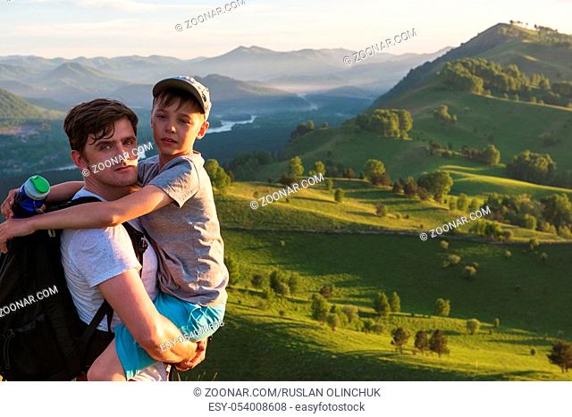 Happy father and son are walking in the Altai mountains