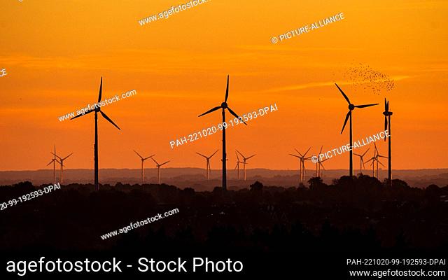 20 October 2022, Lower Saxony, Syke: Wind turbines stands out against the red glowing sky. Today from the west dense clouds and rain advancing to about the Elbe