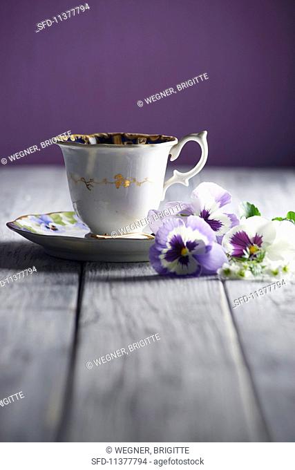 A cup of coffee and pansies