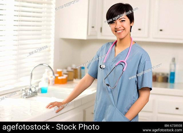 Smiling attractive mixed-race doctor or nurse in an office or laboratory setting