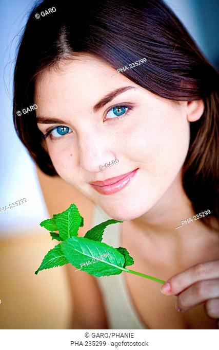Woman smelling mint leaves Mentha sp