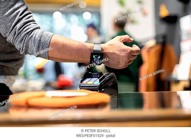 Customer paying contactless with his smartwatch
