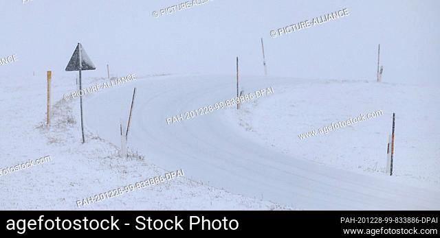 28 December 2020, Bavaria, Stötten: A side road marked with poles runs through the snow-covered Allgäu landscape. Photo: Karl-Josef Hildenbrand/dpa