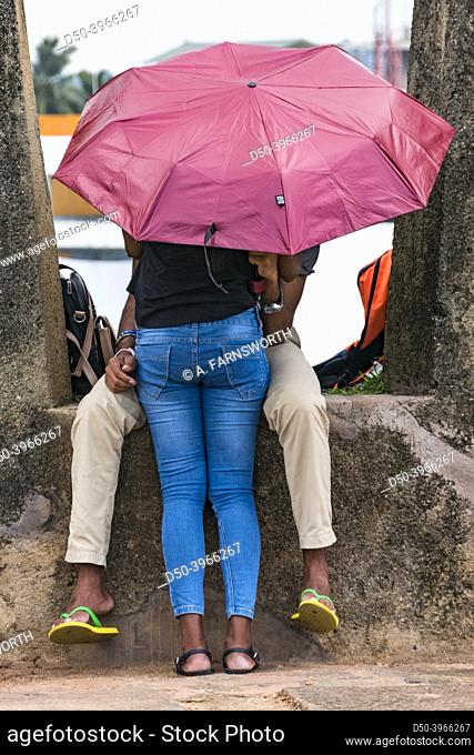 Galle, Sri Lanka A young coupole making out under an umbrella in the old fort