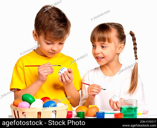 Two children painting Easter eggs isolated on white background