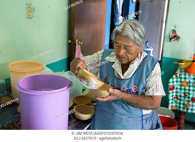 Santiago Matatlán, Oaxaca, Mexico - A woman who sells pulque that her family produces pours a sample for visitors to taste