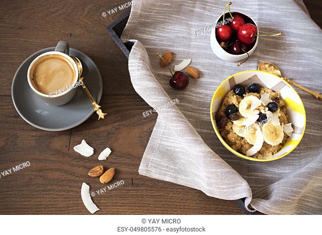 Almond Milk Quinoa With Fresh Fruits, Cherries And Coffee in a Tray. Healthy Breakfast, Lifestyle Concept. Top View. Dark Wooden Background