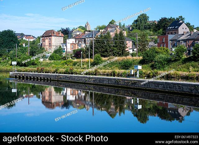 Namur, Wallon Region, Belgium, 07 28 2022 - Worker houses reflecting in the banks of the River Sambre
