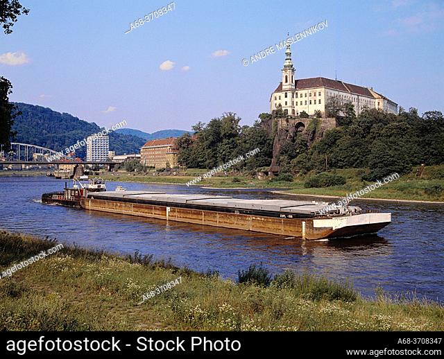 A freight barge on the river Elbe in front of the castle in Decin, Czech Republic