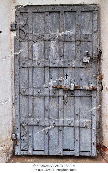 Closeup of ancient rusty iron gate with padlock