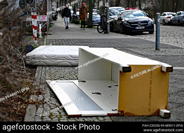 PRODUCTION - 02 February 2023, Berlin: A discarded mattress and a damaged cupboard lie on a sidewalk. Berlin has to vote again because of breakdowns