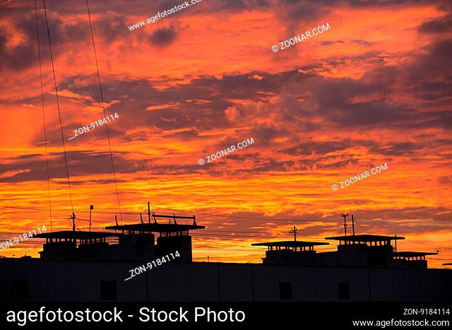 Natural background of colorful red sky during sunset time with street roofs