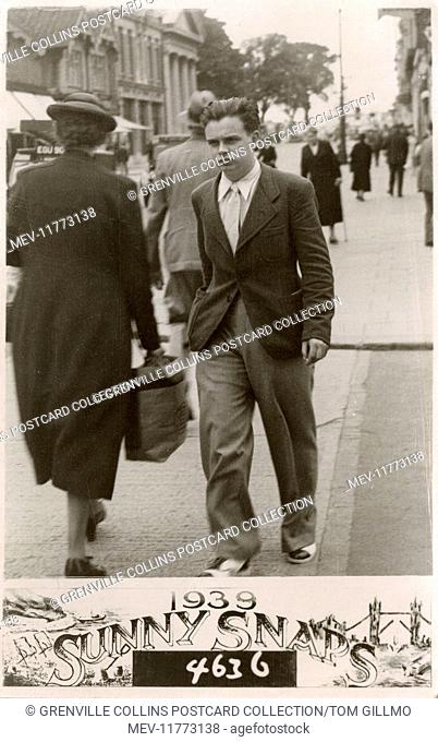 Stylish young man (note the fantastic voluminous trousers and co-respondent sytle shoes - London brogues) with a rather surly expression striding purposely...