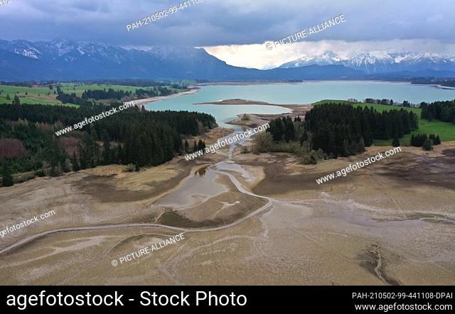 02 May 2021, Bavaria, Roßhaupten: The Illasbergsee (in front), which is fed by the Forggensee in the background, is dry. The Forggensee