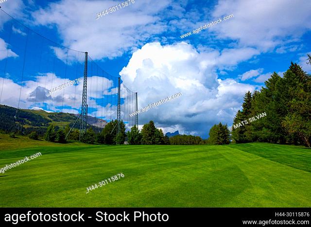 Crans Sur Sierre Golf Course with Driving Range Net and Mountain View in Crans Montana in Valais, Switzerland