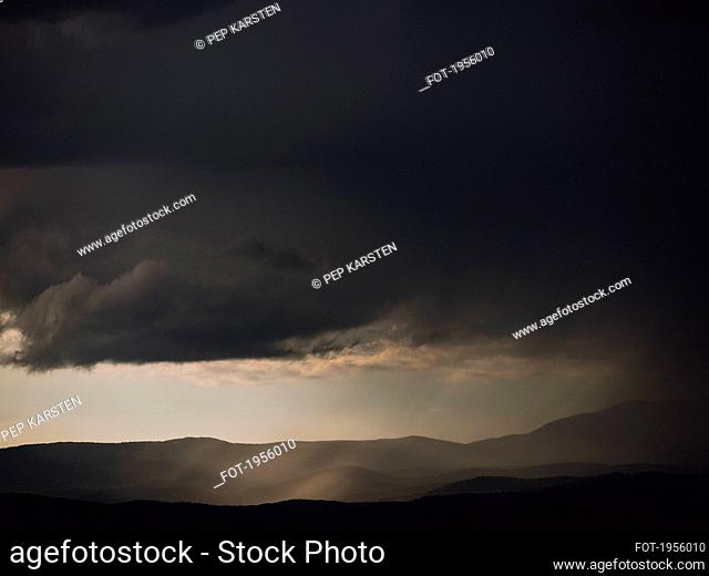 Dark gray storm clouds over silhouetted hills, Auribeau-sur-Siagne, France