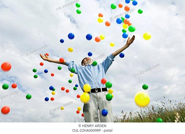 Young boy throwing colored balls
