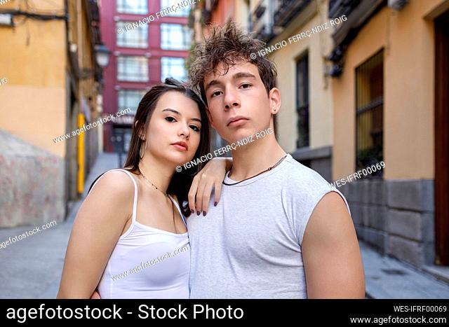 Woman leaning on man shoulder while standing at street