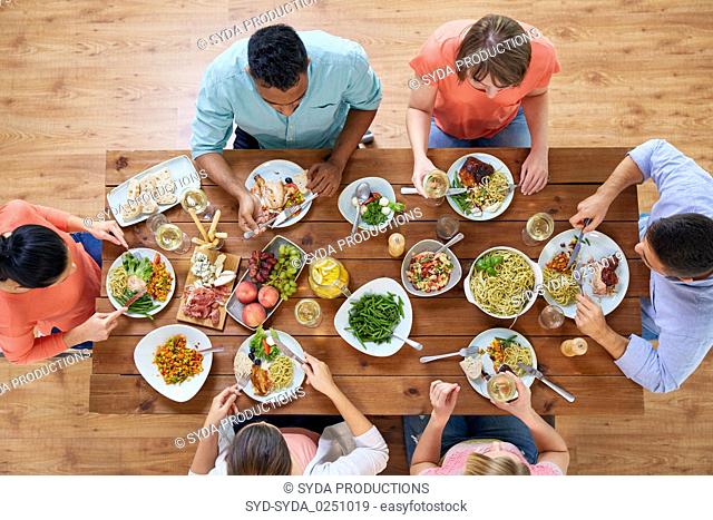 group of people eating at table with food