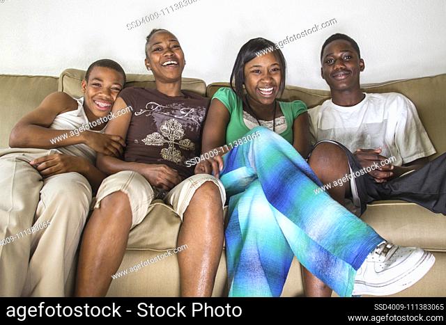 Laughing family sitting on sofa