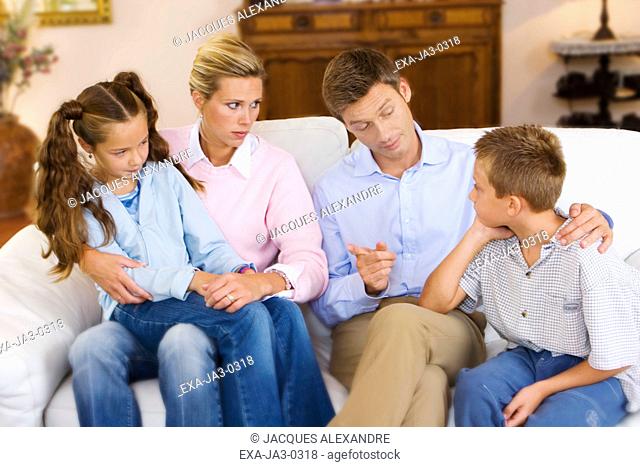 Parents talking to children on sofa