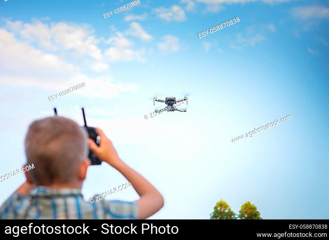 Kid flying drone. Boy operate drones. Child Operating Quadcopter. Little Pilot Using Drone Remote Controller