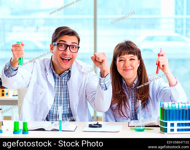 The two chemists working in lab experimenting