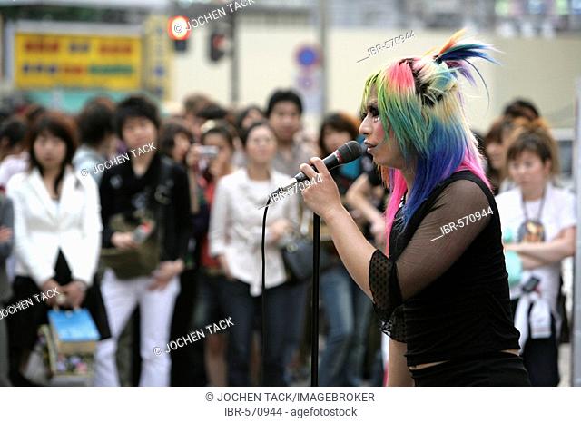 Japan, Tokyo: Shinjuku district. Teenager dancing and head banging to punk music