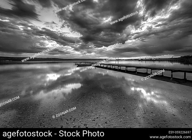 Stunning black and white long exposure seascape with clouds reflection