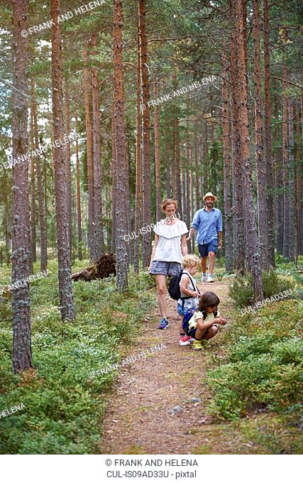 Parents walking through forest with daughters