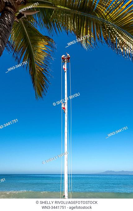 The Pampantla Flying Birdmen climb to the top of a tall pole before performing on the Puerto Vallarta Malecon. The Mexican street performers wear traditional...