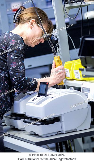 20 March 2018, Germany, Wittenberge: An employee of company Francotyp-Postalia (FP) works on a franking machine. FP employs over 60 people and manufactures...