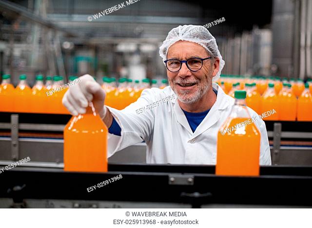 Factory engineer examining a bottle of juice
