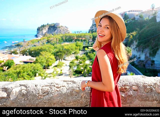 Portrait of attractive fashion model turns around to the camera in Tropea village, Calabria, Italy