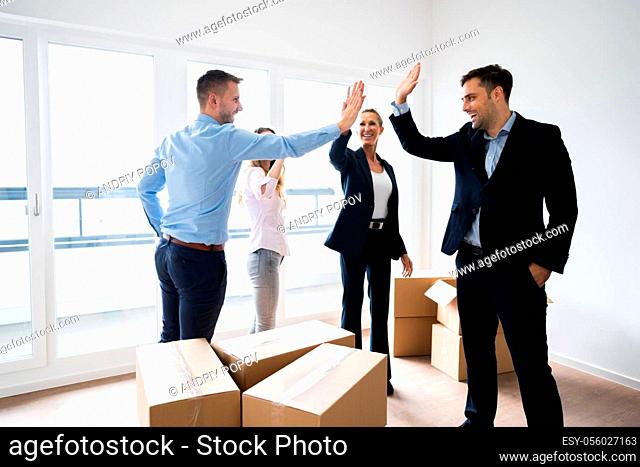 Office Relocation. Smiling Executives Making High Five