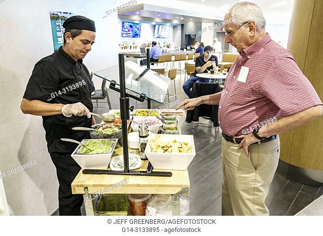 Florida, Miami, International Airport MIA, terminal concourse gate area, American Airlines business class Flagship lounge, dining, taco station, Hispanic, man