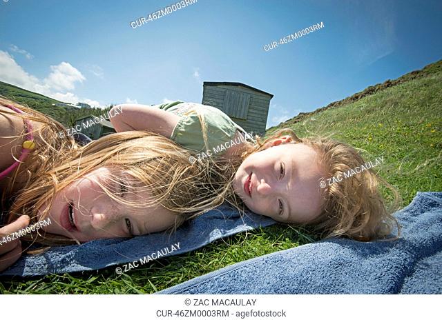Girls laying on towels in grass