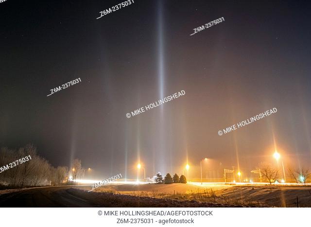 Arctic air combines with river steam and a corn milling plant's steam to produce light pillars, thanks to ice crystals floating in the air from the steam...