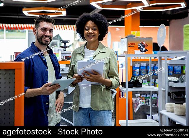 Male and female entrepreneurs standing in hardware shop