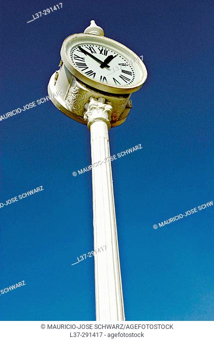 Public clock seen from below against a deep blue sky