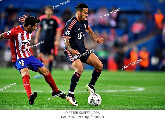 Munich's Thiago Alcantara (R) and Madrid's Augusto Fernandez vie for the ball during the Champions League semi-final match between Atletico Madrid and Bayern...