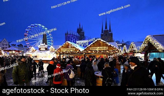 28 November 2023, Thuringia, Erfurt: Lights shine at Erfurt's Christmas market on the opening day. Against the atmospheric backdrop of the cathedral and St