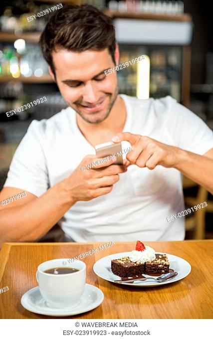 Handsome man taking a picture of his food