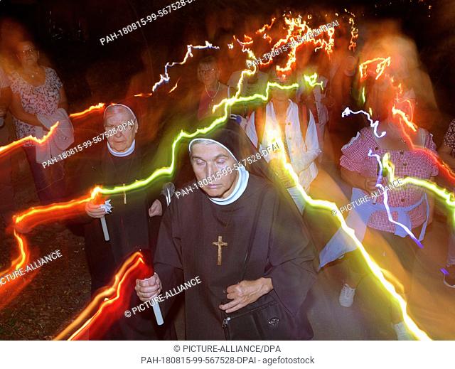 15 August 2018, Germany, Ziemetshausen: Nuns and procession participants honour St. Mary with a procession of lights at the pilgrimage church Maria Vesperbild