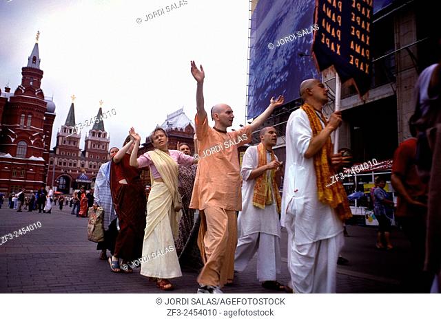 Group of Hare Krishna devotees dancing and singing in the red square of Moscow