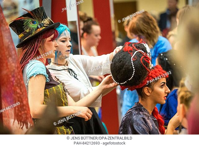 Model Tina, member of the team of the vocational college Rostock, is transformed into the Queen of Hearts from Alice in Wonderland by Lisa Meier (front) and...